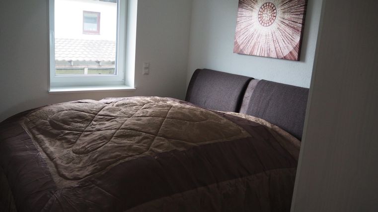 Ein gemütliches Schlafzimmer mit einem großen Bett und einem Fenster. An der Wand hängt ein dekoratives Bild.