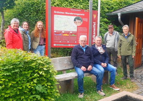 Sieben glückliche Vertreter des Projektes stehen um die neue Informationstafel herum