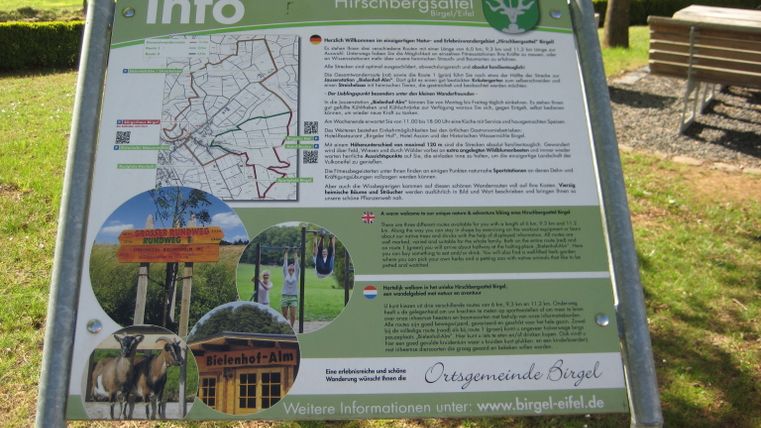 Informationstafel zum Hirschbergsattel in Birgel mit Wanderkarte und Bildern.