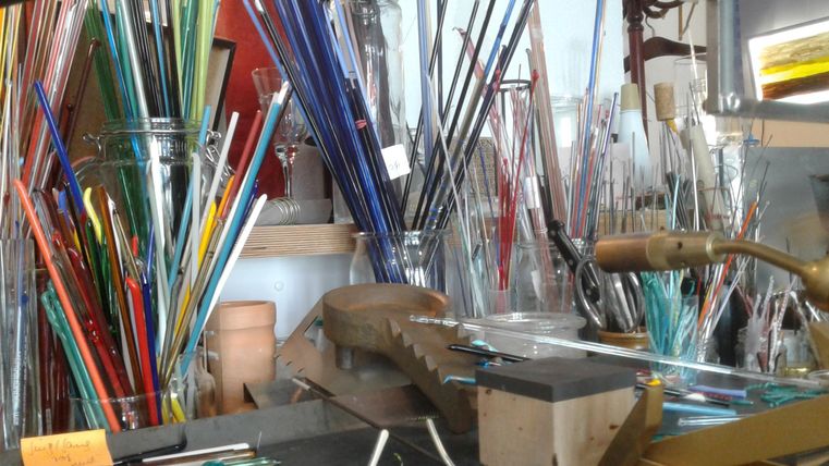 Arbeitsplatz mit verschieden farbigen Glasröhrchen und Werkzeug