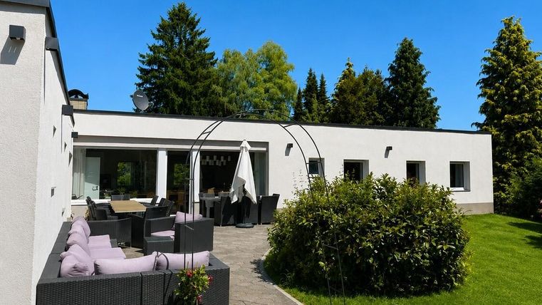 Une maison moderne avec un bel espace extérieur.
Des pelouses verdoyantes et des zones assises invitent à la détente.