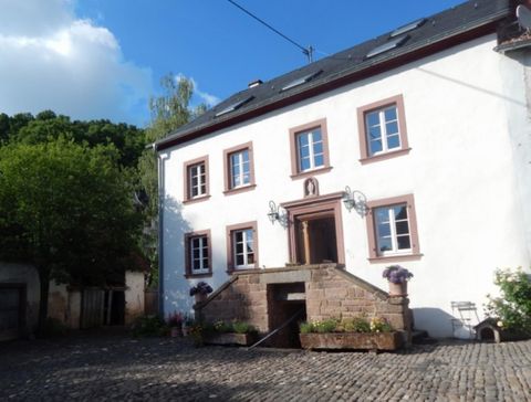 weißes, restauriertes ehemaliges Bauernhaus mit Treppe vor dem Eingang
