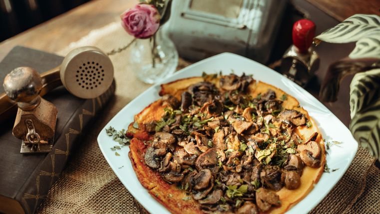 Champignonpizza auf weißem Teller.