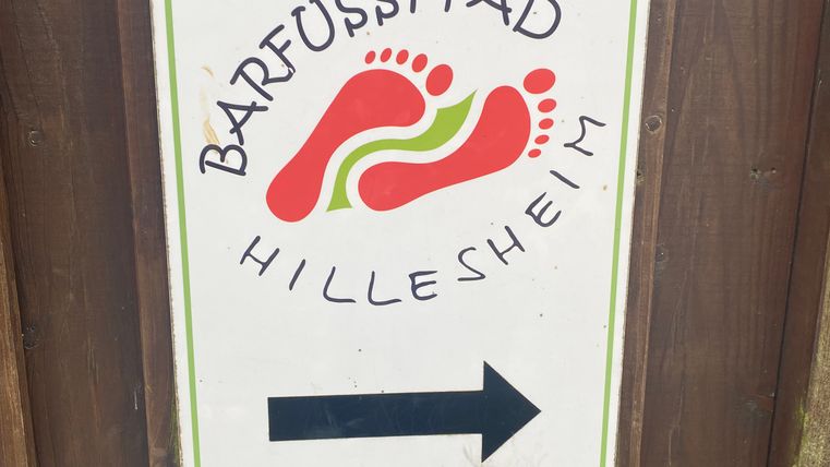 Schild mit der Aufschrift 'Barfußpfad Hillesheim' und einem Pfeil nach rechts.