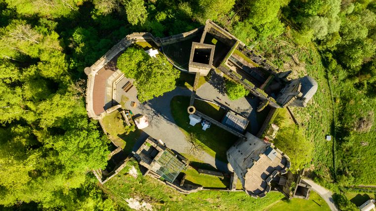 Von oben fotografierte Burg mit dichtem Wald rundherum.