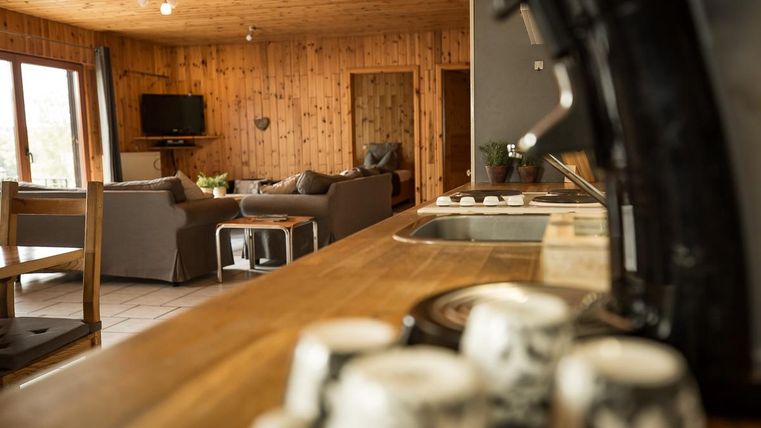 Eine gemütliche Wohnung mit Holzvertäfelung und einem offenen Wohnbereich. Die Küche ist gut ausgestattet und bietet eine einladende Atmosphäre.