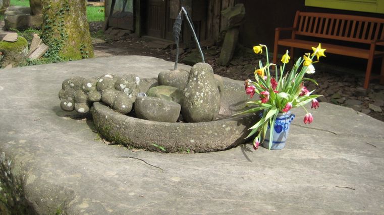 Steinskulptur mit Blumenstrauß in der Künstlersiedlung Weissenseifen.