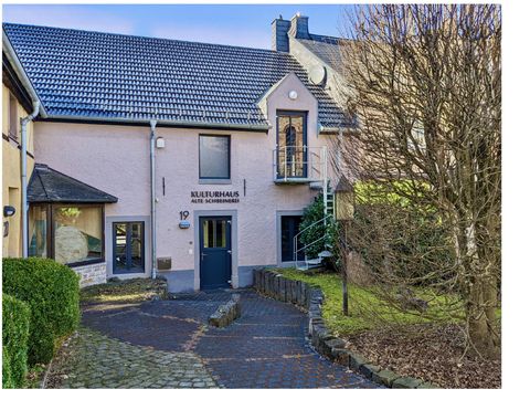 Eingang des Kulturhauses Alte Schreinerei mit gepflastertem Weg, Treppe und kahlem Baum im Vordergrund.