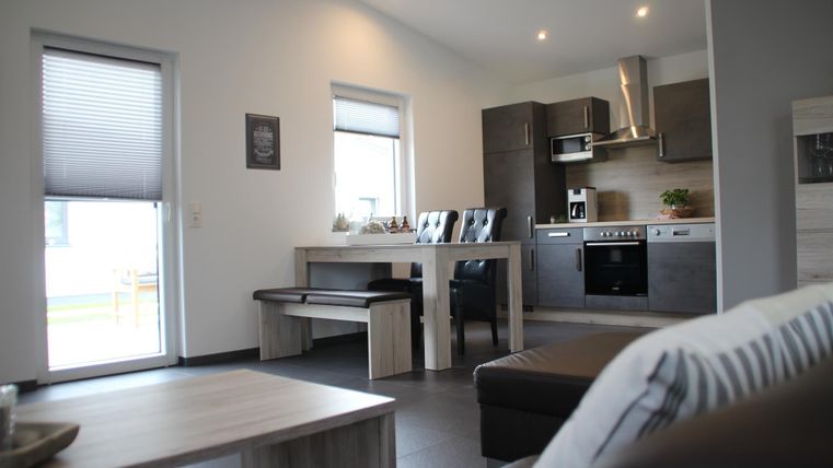 Ein modernes und freundliches Wohn-Esszimmer mit einer offenen Küche. Der Raum ist hell erleuchtet und bietet Platz für einen Esstisch sowie eine gemütliche Sitzgelegenheit.