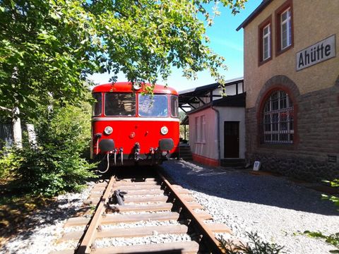 Vue extérieure du bâtiment du musée. Une ancienne locomotive à vapeur rouge est garée devant.
