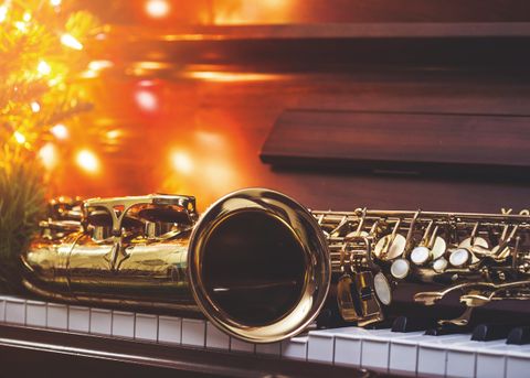 ein Saxophon liegt auf einem Piano