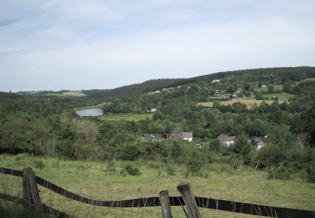 Green landscape with a view of Lake Kronenburg, surrounded by hills and wind turbines in the background., &copy; Touristik GmbH Gerolsteiner Land