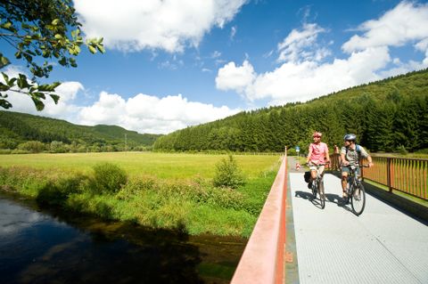 zwei Radfahren fahren über eine Brücke