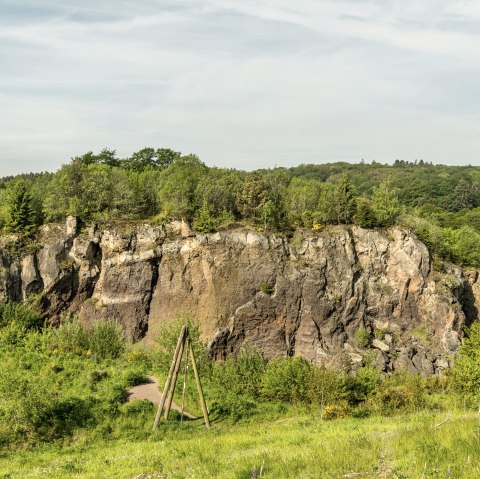 Felsigen Vulkanwand in einer gr&uuml;nen Landschaft.
