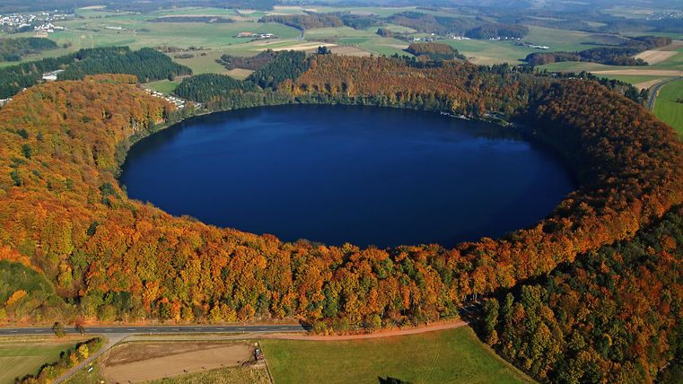 Luchtfoto van de Pulvermaar, omgeven door herfstkleurige bossen.