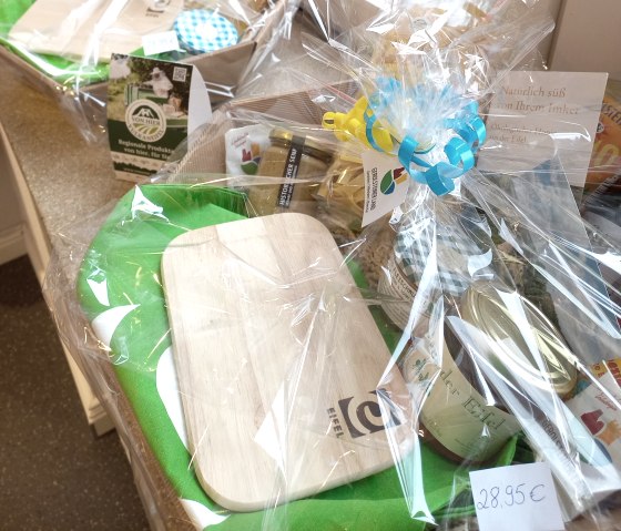 Ein schön verpackter Geschenkkorb mit zahlreichen regionalen Lebensmitteln und Produkten.