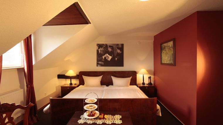 Une chambre moderne avec un lit double et un éclairage confortable. Sur la table se trouve un plateau avec des collations.