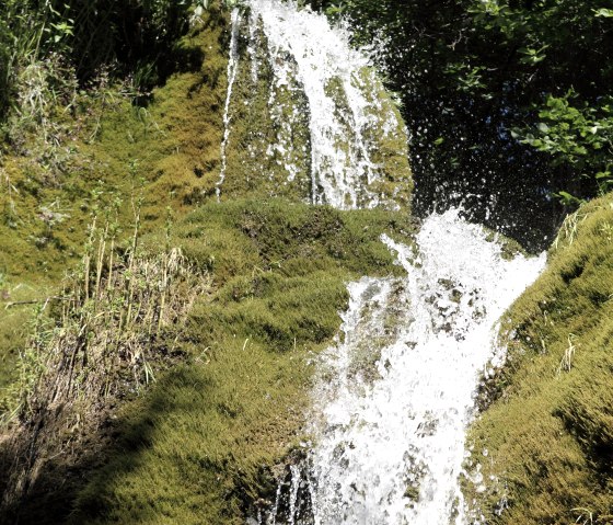 Close-up van het water dat langs de met mos bedekte rots van de Dreim&uuml;hlen waterval naar beneden stroomt., &copy; Thomas Regnery