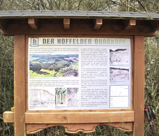 Wooden panel with information and pictures of the Hoffelder Burgkopf, a former basalt quarry surrounded by trees., &copy; Touristik GmbH Gerolsteiner Land, Ute Klinkhammer