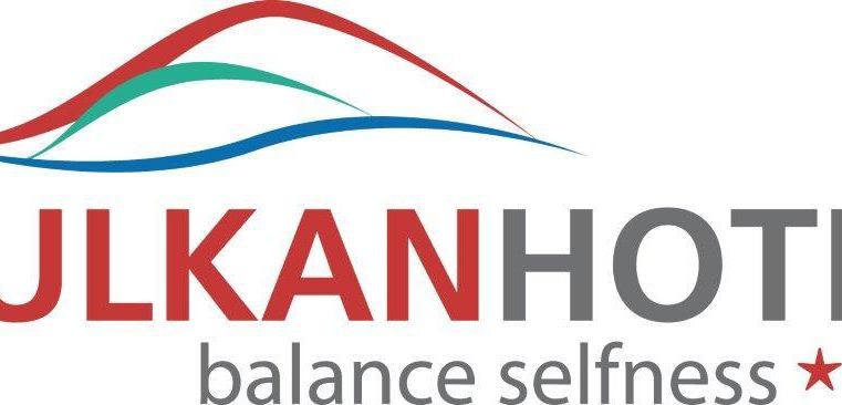 Le logo de l'hôtel volcan avec le slogan "Balance Selfness" et trois étoiles. Il représente un paysage montagneux stylisé dans les couleurs rouge, bleu et vert.