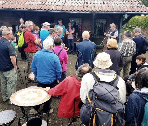 Wandergruppe steht zusammen und schaut zu Moderator