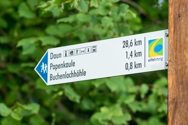 Wanderweg Wegweiser mit Entfernungsangaben zu Sehenswürdigkeiten und Wanderwegen.