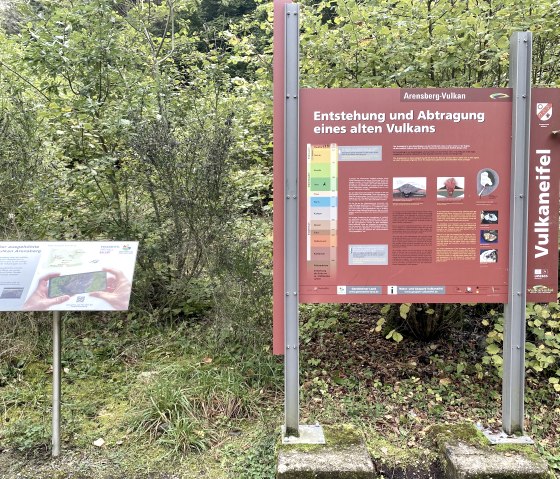 Two information signs in the countryside. On the left a sign about the Arensberg volcano, on the right a larger one about the Volcanic Eifel., &copy; Touristik GmbH Gerolsteiner Land