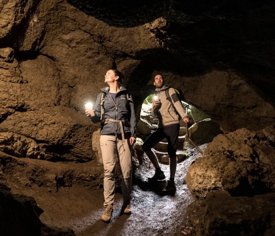 Two hikers inside the millstone caves of the Rother Kopf., © Eifel Tourismus GmbH, Dominik Ketz