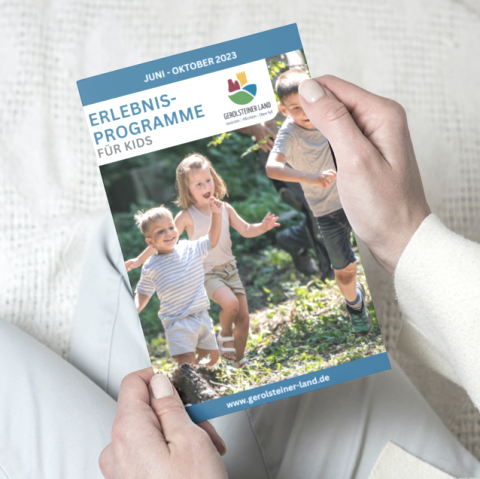 Das Prospekt "Erlebnisprogramme f&uuml;r Kids" im Zeitraum Juni - Oktober 2023 wird hochgehalten