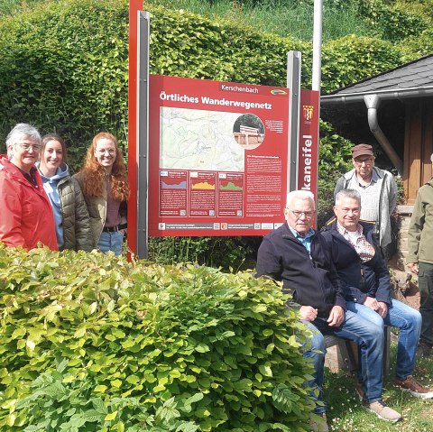 Sieben glückliche Vertreter des Projektes stehen um die neue Informationstafel herum
