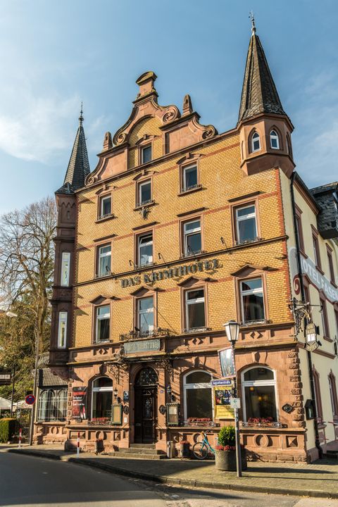 Das Krimihotel in Hillesheim, ein historisches Gebäude mit Türmen und dekorativen Elementen, bei sonnigem Wetter.