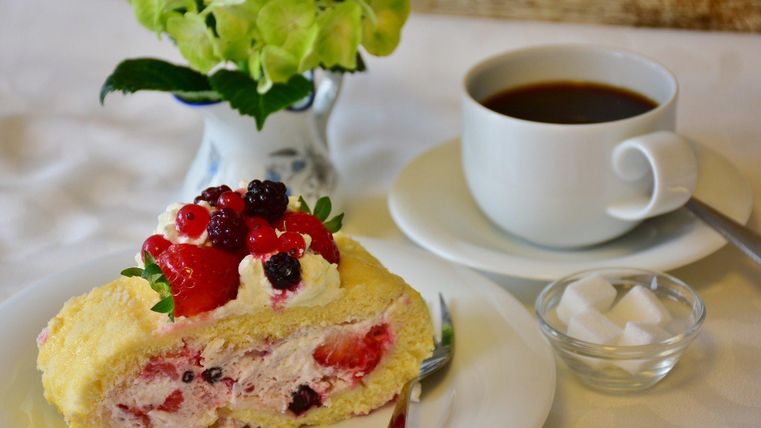 Stück Kuchen mit einer Tasse Kaffee