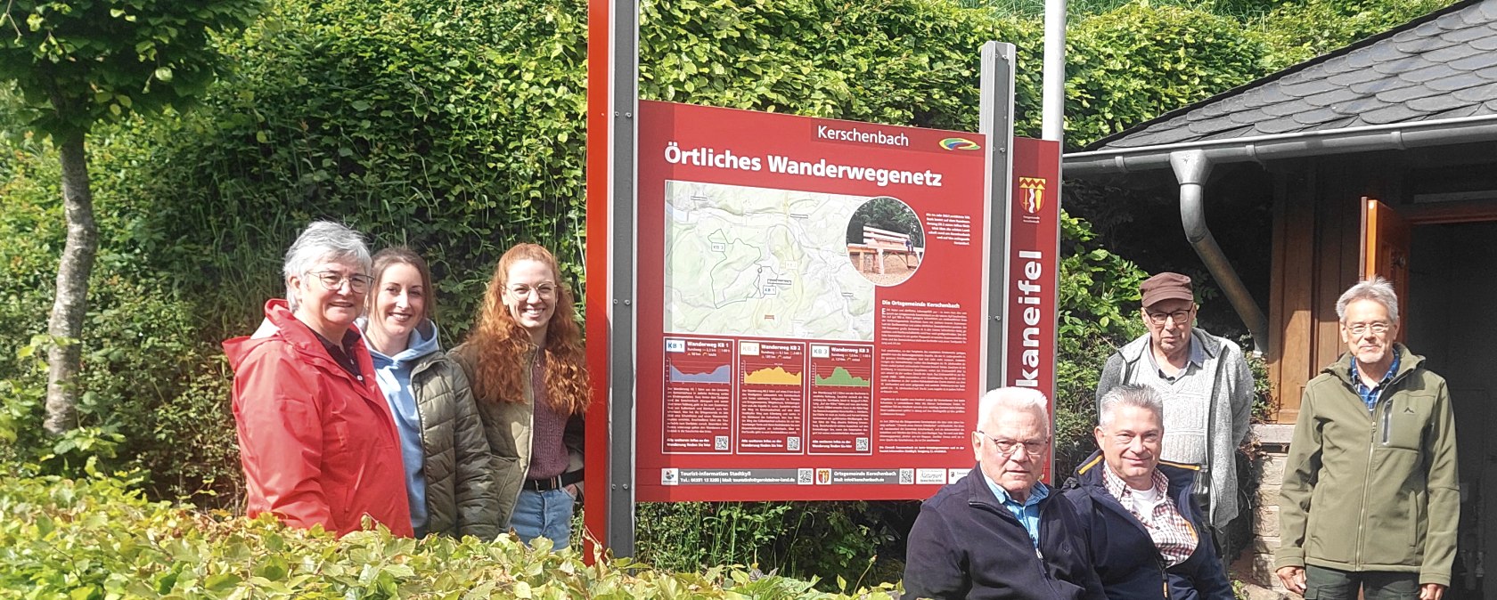 Sieben glückliche Vertreter des Projektes stehen um die neue Informationstafel herum