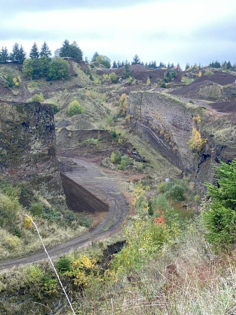 Ici, on a une vue sur le volcan. On aperçoit des collines légèrement boisées. Le ciel est nuageux.