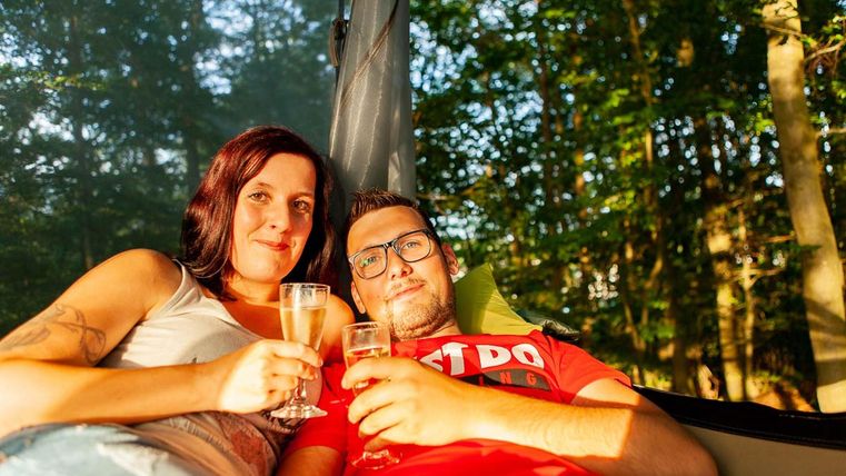 Zwei Menschen in einer Hängematte mit Sekt