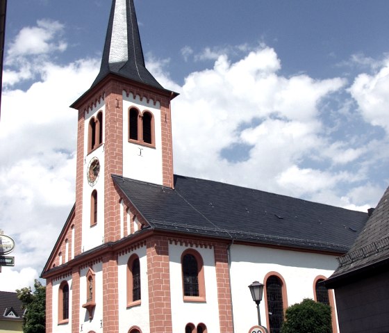 The church of St. Josef in Stadtkyll with its pointed tower and red brickwork against a blue sky., © Touristik GmbH Gerolsteiner Land