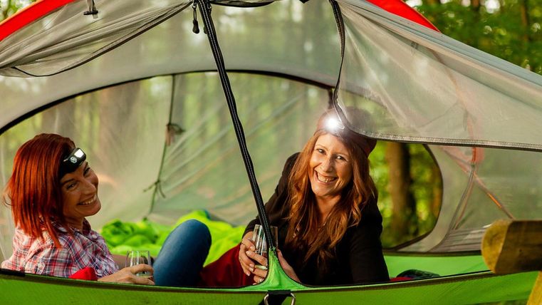 Zwei Frauen im Baumzelt mit Stirnlampe