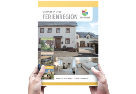 Es wird das Magazin hochgehalten. Auf der Titelseite erkennt man eine Unterkunft. Hintergrundfarbe des magazins ist gelb, &copy; Touristik GmbH Gerolsteiner Land