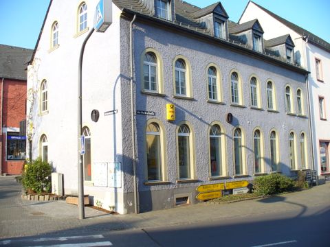 Außenfassade der Tourist-Information Hillesheim mit Deutscher Post Filale und DHL Shop.