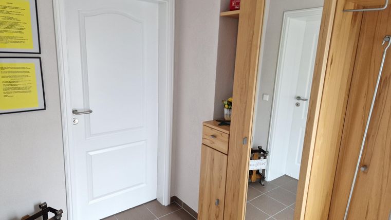 Eingangsbereich mit einer weißen Tür und einem Garderobenschrank