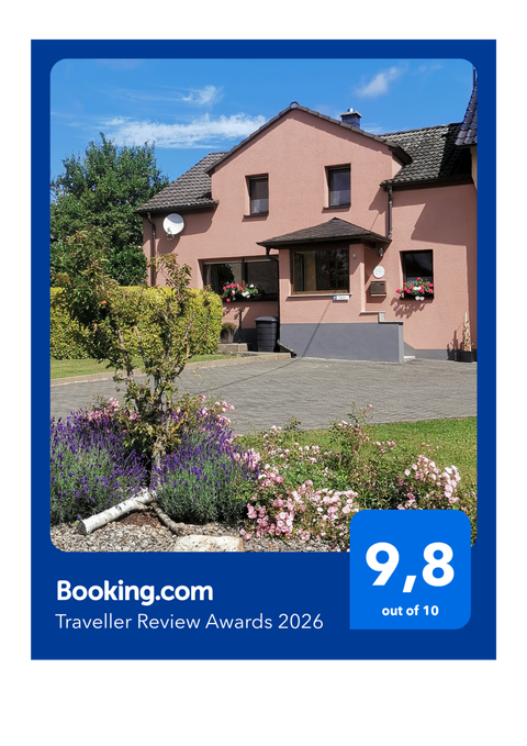Auszeichnung von booking.com für die Ferienwohnung am Wasserfall mit Bild der Unterkunft von außen.
