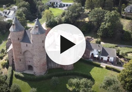 Aerial view of Bertrada Castle in M&uuml;rlenbach with video play button in the foreground.