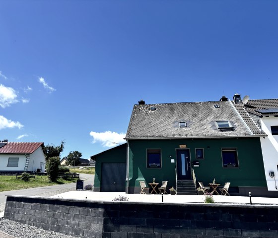 Außenansicht der Pension mit Parkplatz