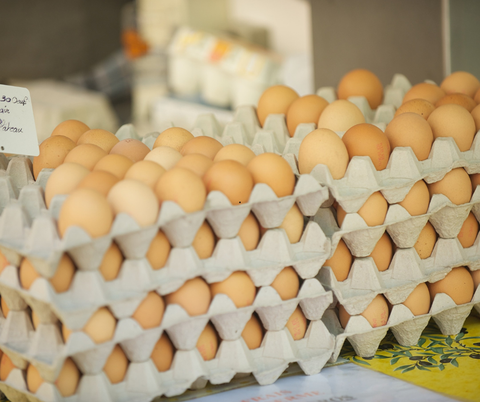 Mehrere gefüllte Eierpaletten sind aufeinander gestapelt und stehen zum Verkauf.