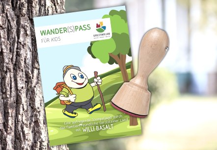 Titelseite "Wander(S)pass f&uuml;r Kids" mit einem Stempel vor einem Baum