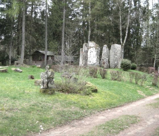 Weissenseifen Sculpture Park: stone sculptures on a green meadow, surrounded by trees and a forest path., © Touristik GmbH Gerolsteiner Land, Ute Klinkhammer