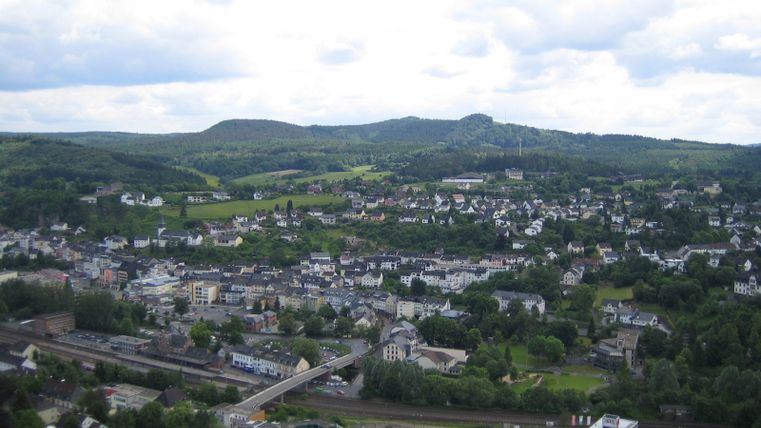 Panoramablick auf Gerolstein von der Munterley mit grünen Hügeln im Hintergrund.