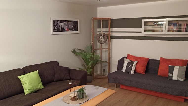 Un salon moderne avec deux canapés aux couleurs neutres. Une table en bois et une plante complètent l'ambiance chaleureuse.