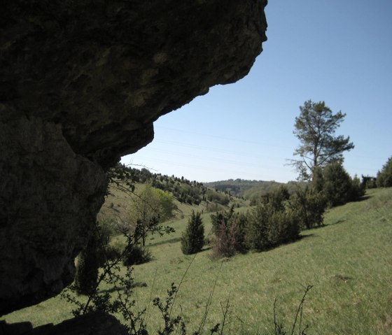 Rocky outcrop in the foreground, green hilly landscape with trees and blue sky in the background., © Touristik GmbH Gerolsteiner Land