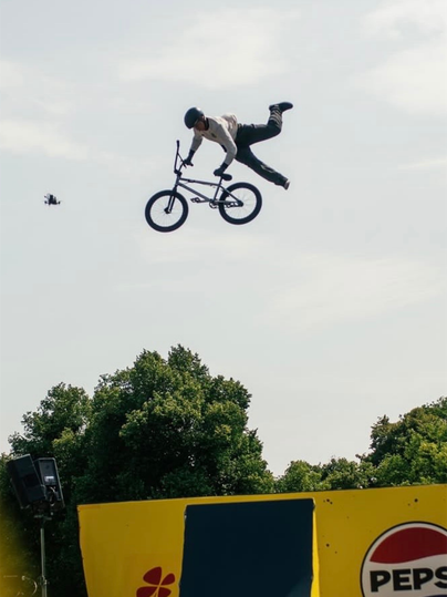 Ein BMX-Fahrer führt während eines hohen Sprungs einen anspruchsvollen Trick aus